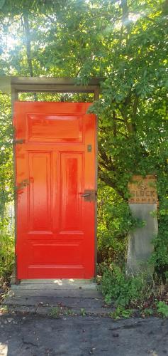 una puerta roja en medio de un jardín en GLÜCK HOMES Baumhaus en Ippesheim