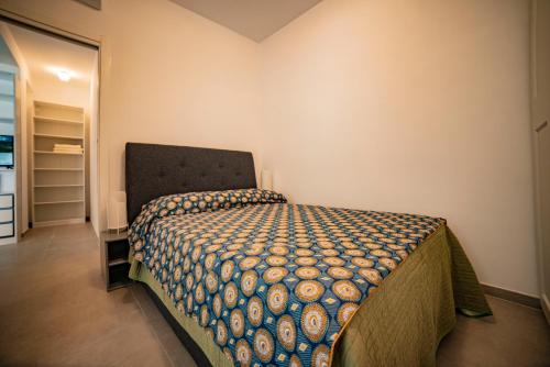 ein Schlafzimmer mit einem Bett mit einer Decke darauf in der Unterkunft WHITE VEIO LODGE in Rom