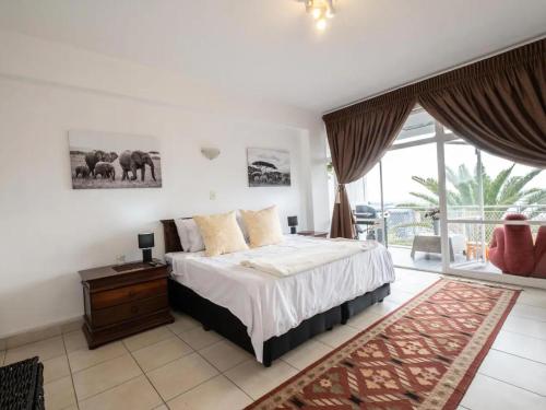 a bedroom with a large bed and a balcony at Lovely 3 Bedroom Unit Sandton in Johannesburg