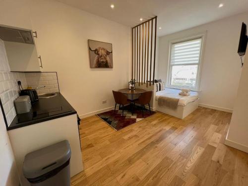 cocina y sala de estar con mesa y cama en 208, The Kové, West Hill Road, en Bournemouth