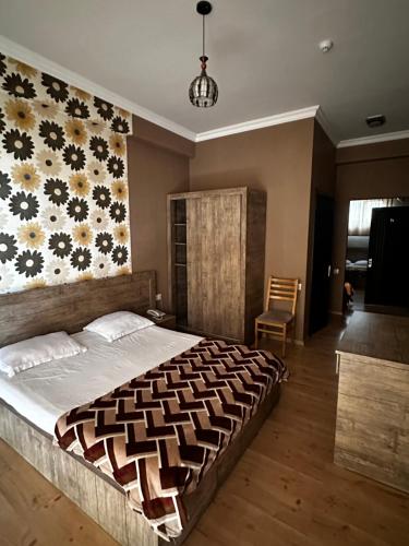 a bedroom with a large bed with a floral wall at Hotel Nirvana in Tbilisi City
