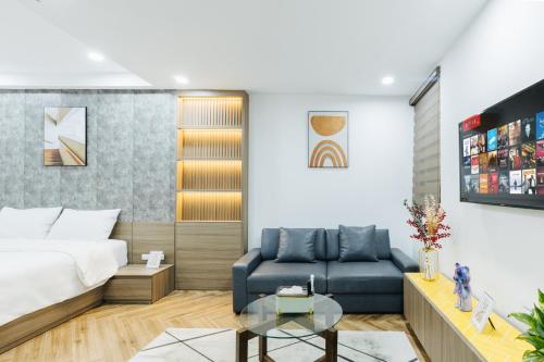 a bedroom with a bed and a blue couch at Westlake Emerald Suites in Hanoi