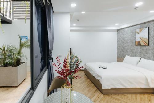 a bedroom with a bed and a table with a vase at Westlake Emerald Suites in Hanoi