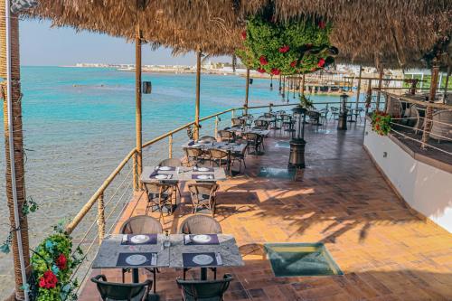 a restaurant on the beach with tables and chairs at Lagoona Beach Luxury Resort and Spa in Manama