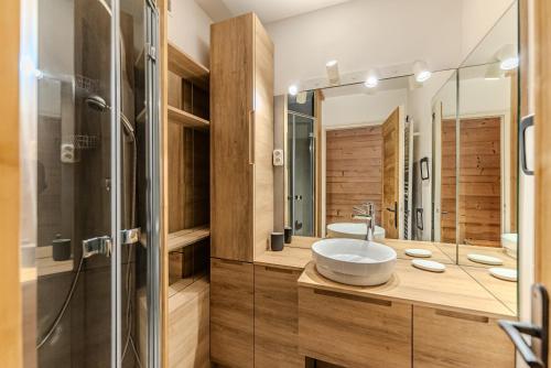 ein Badezimmer mit Waschbecken und Glasdusche in der Unterkunft Appartement La Terrasse de Roma - LES GETS, en plein centre et au pied des pistes in Les Gets