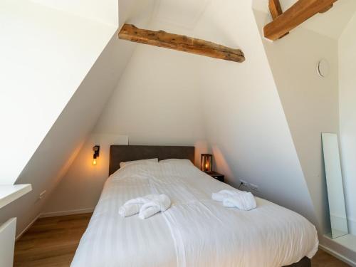 een slaapkamer met een bed met twee handdoeken erop bij 2 adjacent apartments in the heart of Sneek in Sneek