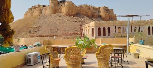 een patio met stoelen en een kasteel op de achtergrond bij The Desert Blabla Hostel in Jaisalmer