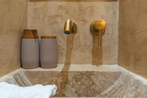 two vases sitting on a bath tub with a faucet at Manus Dei Exclusive Suites in Pythagoreio