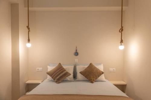 a bedroom with a bed with three pillows at Manus Dei Exclusive Suites in Pythagoreio