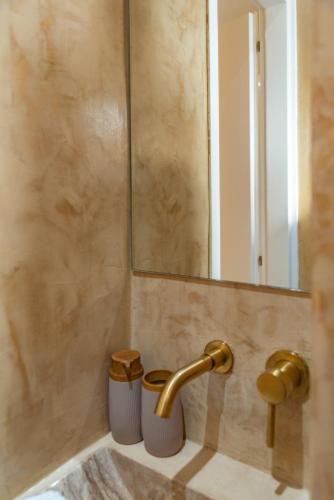 a bathroom with a sink and a mirror at Manus Dei Exclusive Suites in Pythagoreio