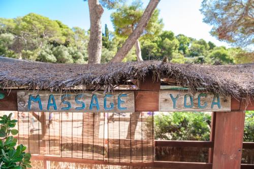 a sign with a thatched roof on a fence at Hotel Cala Dor - Adults Only in Cala d´Or