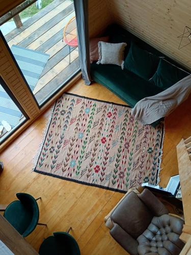 sala de estar con sofá y alfombra en CarpatinA Rustic House, en Runcu