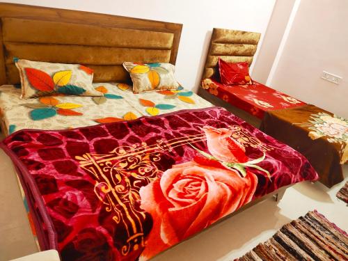 a bedroom with two beds with colorful blankets and pillows at Deviksha Home Stay in Ujjain