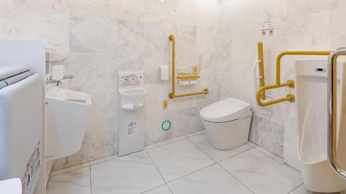 a bathroom with a toilet and a sink and a urinal at Toyoko Inn Osaka Namba in Osaka
