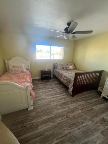 - une chambre avec 2 lits et un ventilateur de plafond dans l'établissement Desert oasis, à La Quinta