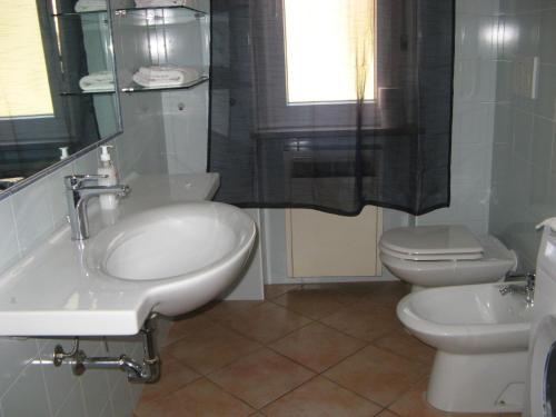 a white bathroom with a sink and a toilet at appartamento vicino al centro in Verona
