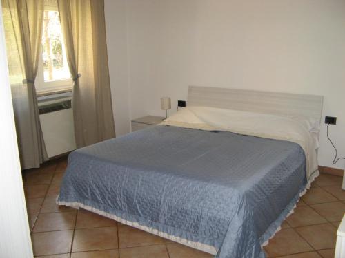 a bedroom with a bed with a blue blanket at appartamento vicino al centro in Verona
