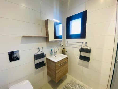 baño con lavabo y aseo y ventana en Sea view Apartment 5 with roof top terrace, Almyrida, en Almyrida