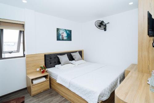a small bedroom with a bed and a tv at Thanh Măng Hotel in Quang Ninh