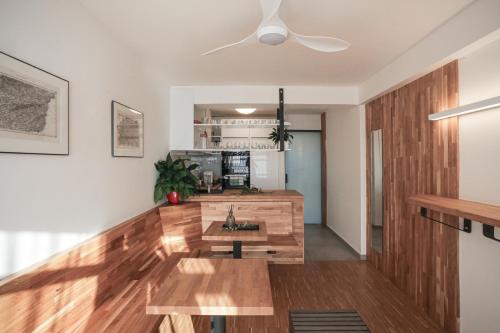 a living room with wooden floors and a ceiling fan at Pár pokojů microhotel in Zlín