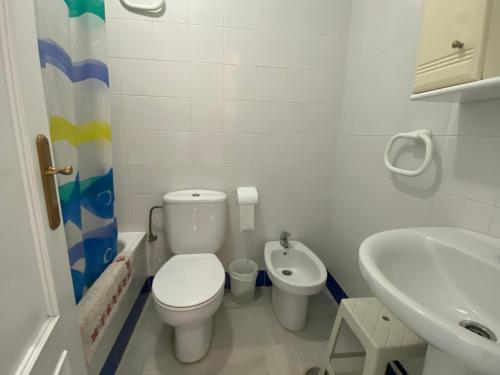 a small bathroom with a toilet and a sink at Apartamento Costa de Sancti Petri by Chiclana Dreams in Novo Sancti Petri