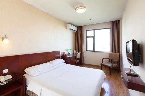 een hotelkamer met een bed en een televisie bij Milo Hotel - Near Shanghai Hongqiao National Exhibition Center in Shanghai