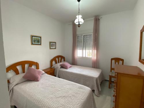 a room with two beds and a window at Apartamento Costa de Sancti Petri by Chiclana Dreams in Novo Sancti Petri