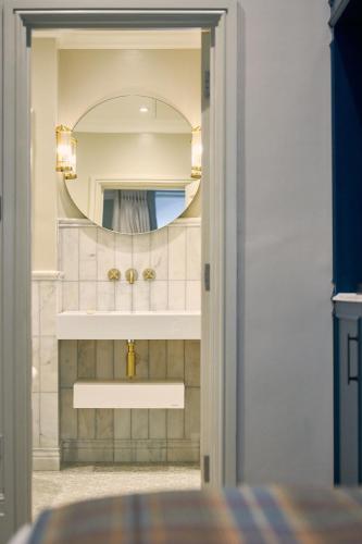 a bathroom with a sink and a mirror at The Tophams Hotel in London