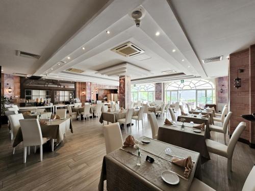 a restaurant with tables and chairs in a room at Hotel Scapolatiello in Cava deʼ Tirreni