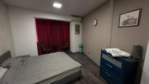 a bedroom with a bed and a dresser and a window at Apartment in central Bucharest in Bucharest