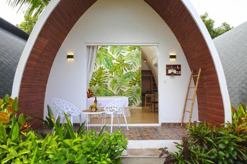an archway leading into a house with a table and chairs at Eden Beach Resort By EHM in Koh Rong Sanloem