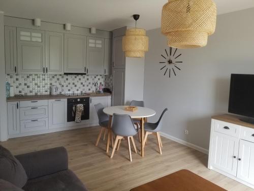 uma cozinha com mesa e cadeiras num quarto em FORT Apartament em Malbork