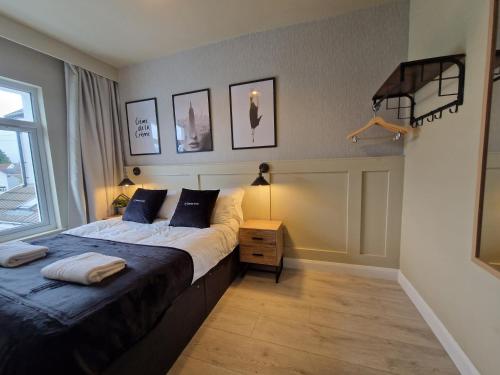 a bedroom with a bed and a nightstand and a window at 3 Bedroom Stylish Home Merthyr in Merthyr Tydfil