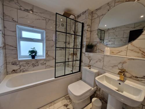 a bathroom with a sink toilet and a mirror at 3 Bedroom Stylish Home Merthyr in Merthyr Tydfil