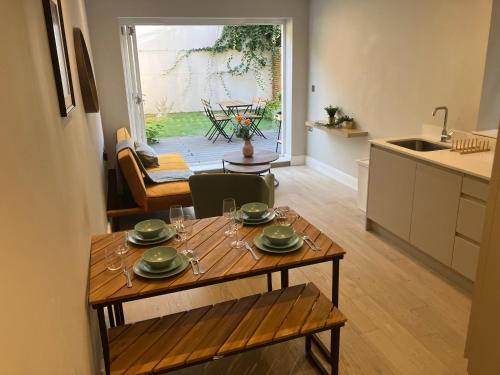 a kitchen and dining room with a table with plates and glasses at Spectacular 2 Bed Apartment With Lovely Terrace - 1 The Southwell in London