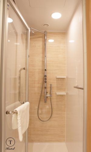 a bathroom with a shower with a glass door at T Hotel Ryuoo in Shimotakai