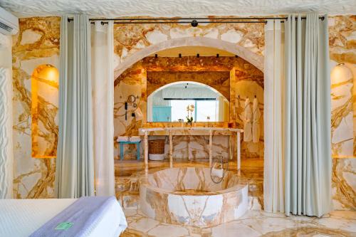 een slaapkamer met een bad in het midden van een kamer bij Agalia Luxury Suites in Tzamaria