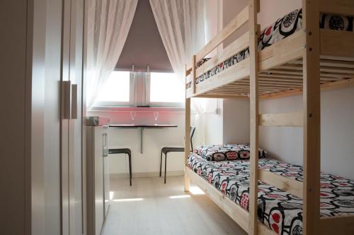 リミニにあるFederico Fellini Apartmentのベッドルーム1室(二段ベッド2組、デスク付)