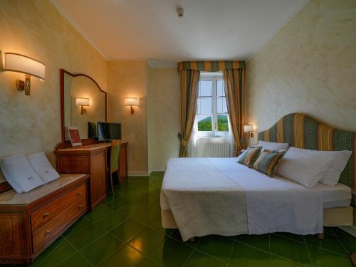 a hotel room with a bed and a window at Hotel Scapolatiello in Cava deʼ Tirreni