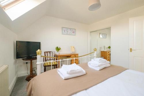 1 dormitorio con 1 cama con toallas en 4 The Birches - Aldeburgh Coastal Cottages en Aldeburgh