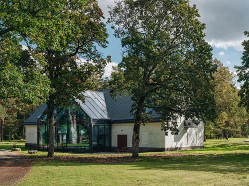 a house with a black roof and two trees at Padise Manor in Padise
