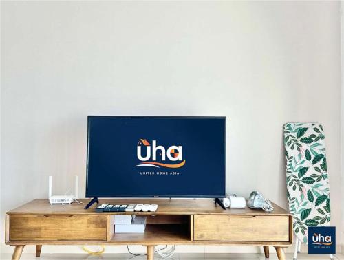 a flat screen tv sitting on top of a wooden entertainment center at Macrolink Medini by RR JBcity in Nusajaya