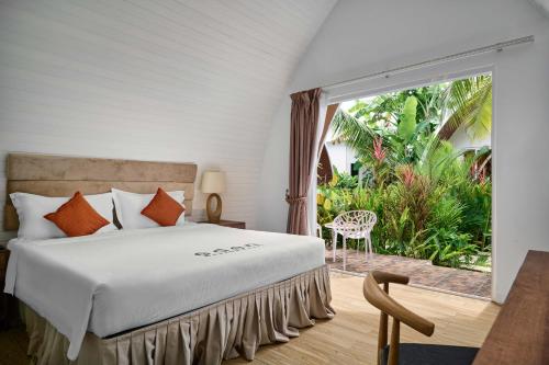 a bedroom with a bed and a large window at Eden Beach Resort by EHM in Koh Rong Sanloem