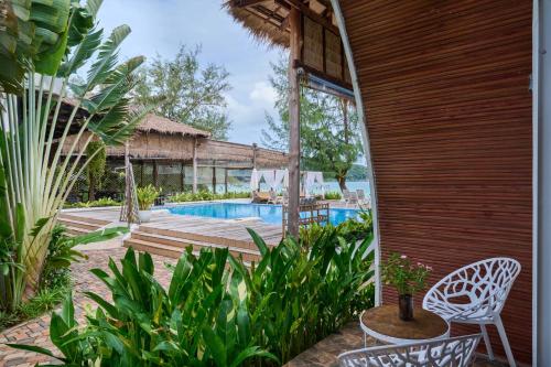 a patio with a swimming pool and a house at Eden Beach Resort By EHM in Koh Rong Sanloem