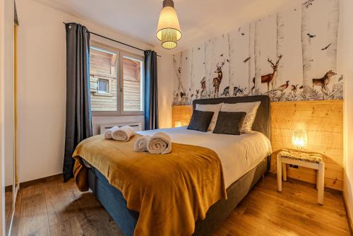 une chambre avec un lit avec des serviettes dessus dans l'établissement Appartement La Terrasse de Roma - LES GETS, en plein centre et au pied des pistes, aux Gets