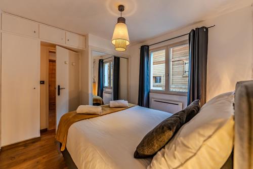 ein Schlafzimmer mit großem Bett und Fenster in der Unterkunft Appartement La Terrasse de Roma - LES GETS, en plein centre et au pied des pistes in Les Gets