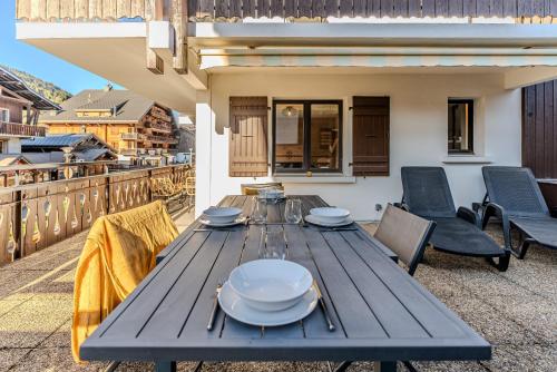 - une table en bois sur le balcon d'une maison dans l'établissement Appartement La Terrasse de Roma - LES GETS, en plein centre et au pied des pistes, aux Gets