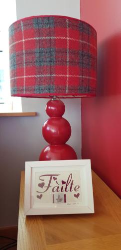 a red lamp sitting on top of a table with a box at No 7 in Back