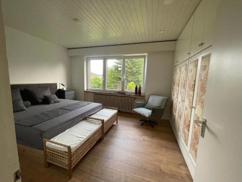 1 dormitorio con 1 cama, 1 silla y 1 ventana en Ferienwohnung im Obstgarten, en Bad Pyrmont