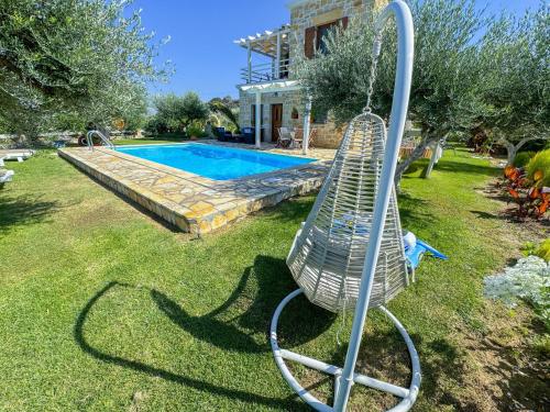 a swing in a yard next to a swimming pool at Private Pool with Sea & Mountain View ,Full Privacy - Villa Kyriaki in Kissamos